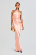 Model in peach satin Everly Dress with lace trim along the halter neckline and hem, floor-length gown.