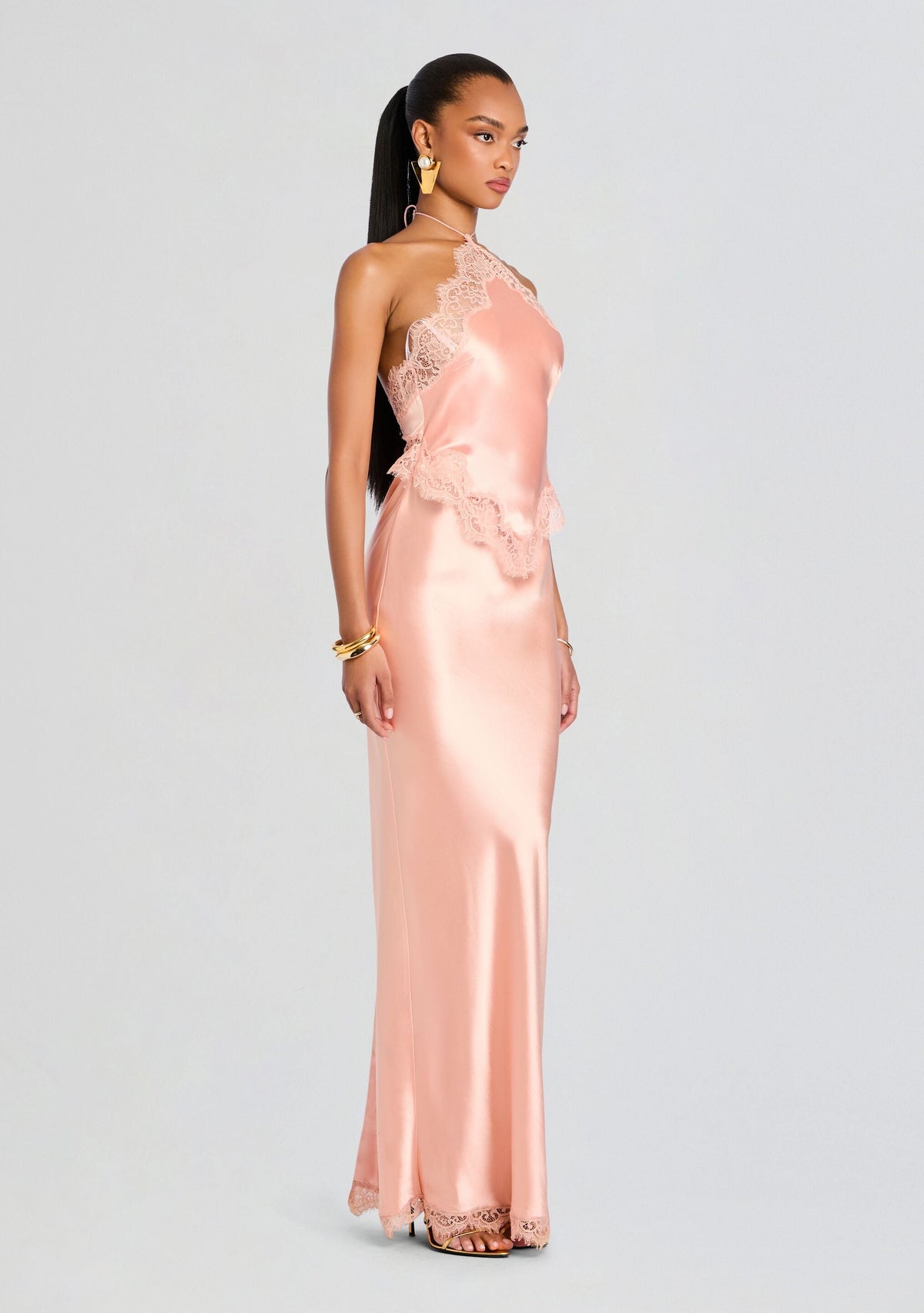 Side view of a model in the blush pink Everly Dress with lace trim along the neckline and hem